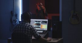 Medium shot of a male actor doing voice over in a sound studio